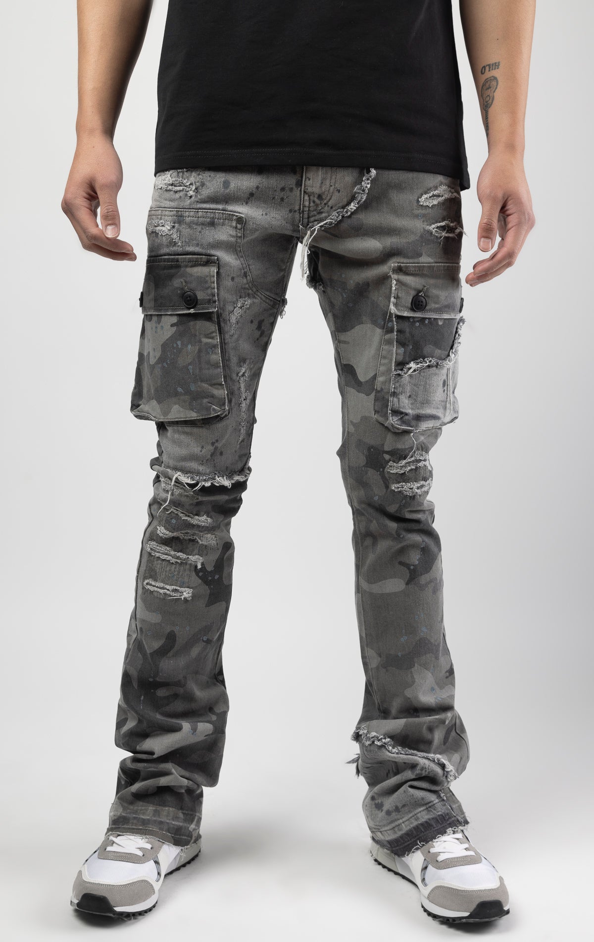 Overcast camo extended length flare pant with a regular rise for maximum stacks. Skinny fit with hand-smearing and speckled paint splatter throughout. Rip and repair detailing, accompanied by cut & sewn woodland camouflage twill patches. Stitching repairs and deep front pocket bags, perfect for large smart phones.